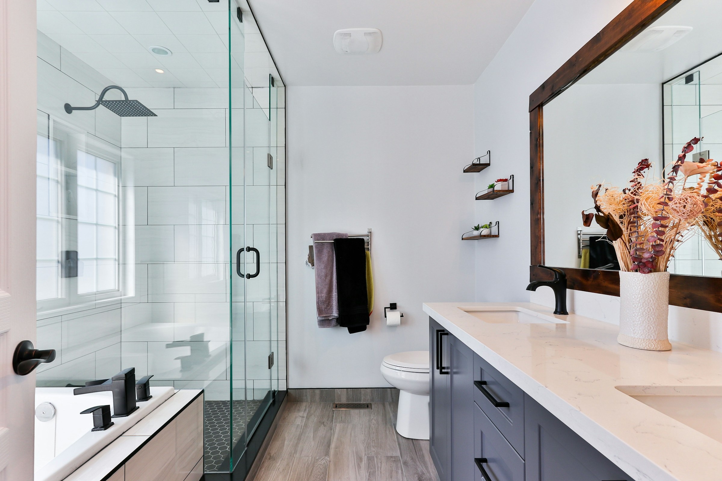 Stand-in photograph of a finished bathroom with a glass shower and stone tile.